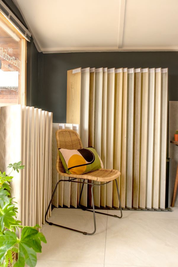 SHOWROOM. Image shows tiles in a showroom with a wicker chair and bright cushion