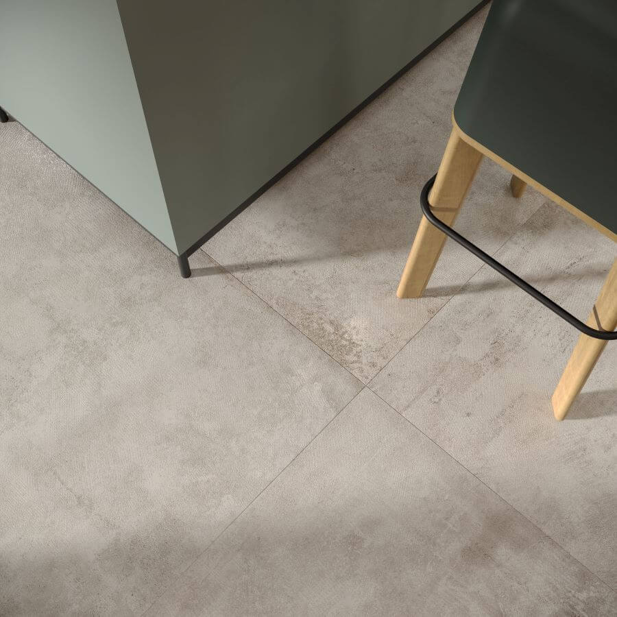 Beat Grey cement look porcelain tile. Image shows grey tiles in kitchen close up with stool