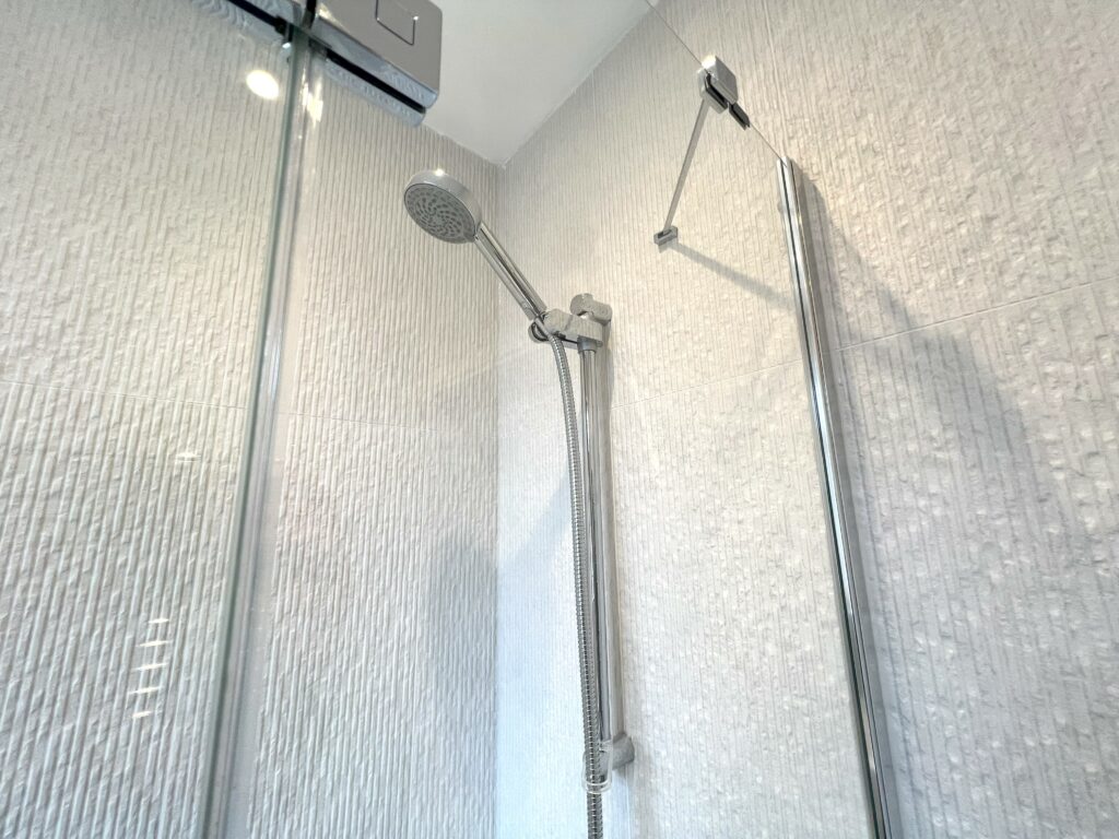 DOCKLANDS-TEXTURED-WALL-TILES. Image shows bathroom with textured wall tiles and shower