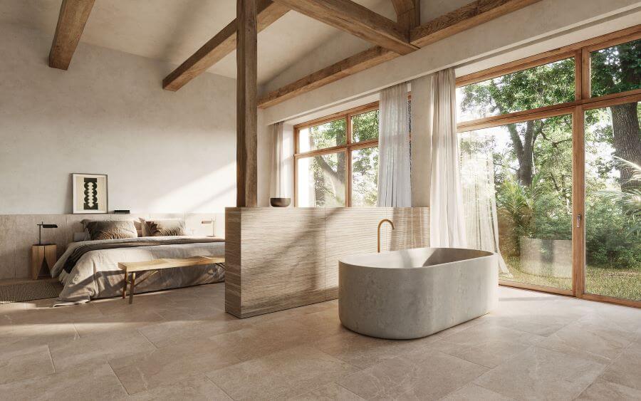 BLISS-STONE-LOOK-FLOOR-TILES-CARAMEL-1. Image shows beige stone look floor tiles in bedroom with bath