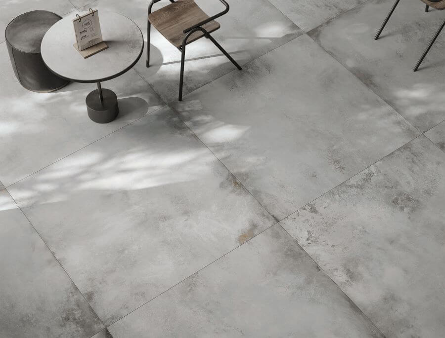 FORGE-TITANIUM-PORCELAIN-METALLIC-TILES-FLOOR. Image shows white porcelain metallic tiles in cafe with table and chair