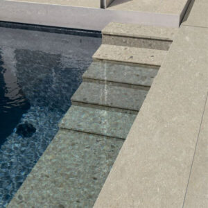 FUSION-LIMESTONE-PORCELAIN-TILES-2CM. Image shows limestone porcelain tiles around swimming pool