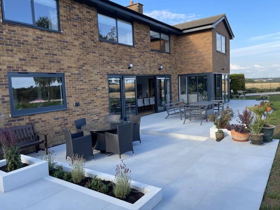 Poise Pebble. Image shows light taupe 2cm porcelain pavers in garden