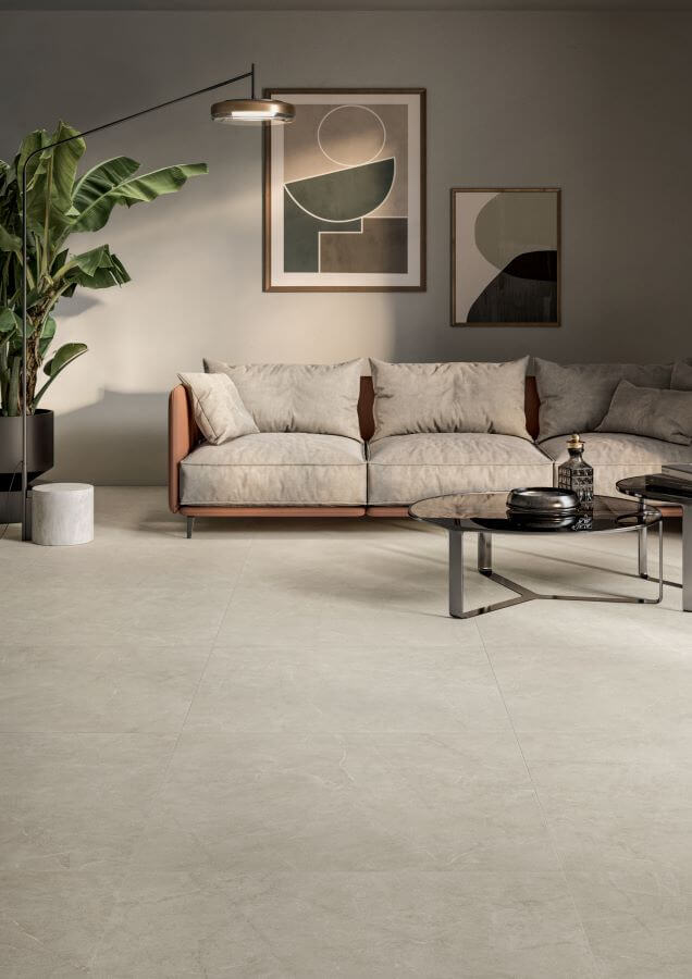 POISE-PEBBLE-STONE-LOOK-PORCELAIN-TILES. Image shows pebble stone look porcelain tiles in a lounge with sofa and table