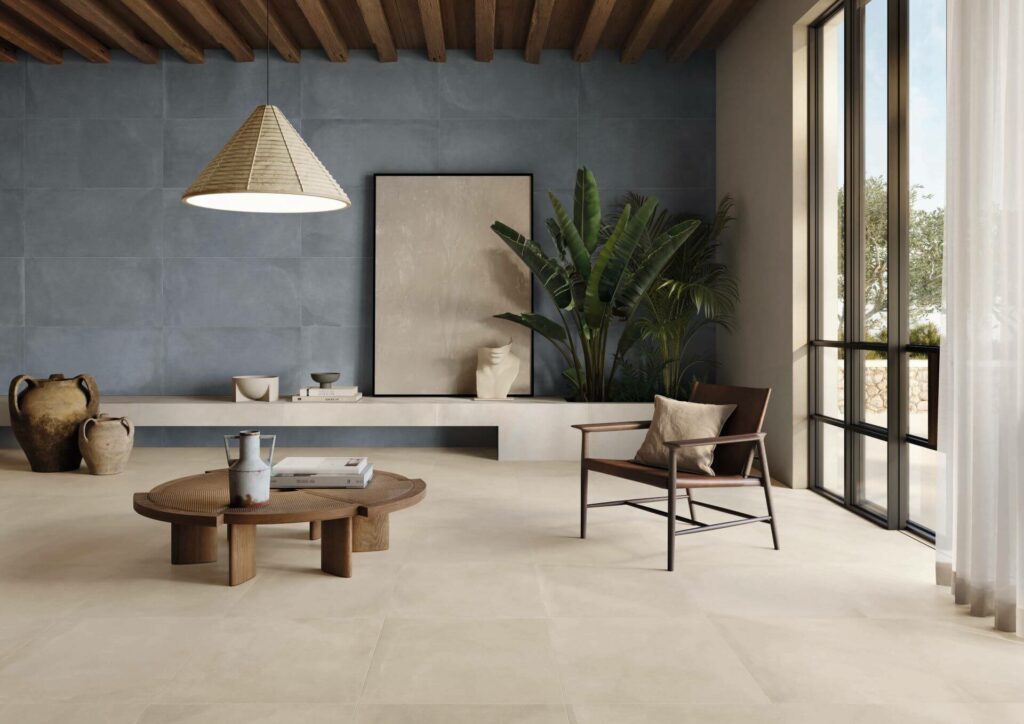 TONE-ECRU-NEW-PORCELAIN-TILES-LOUNGE. Image shows ecru and blue porcelain tiles in a lounge with a chair and table