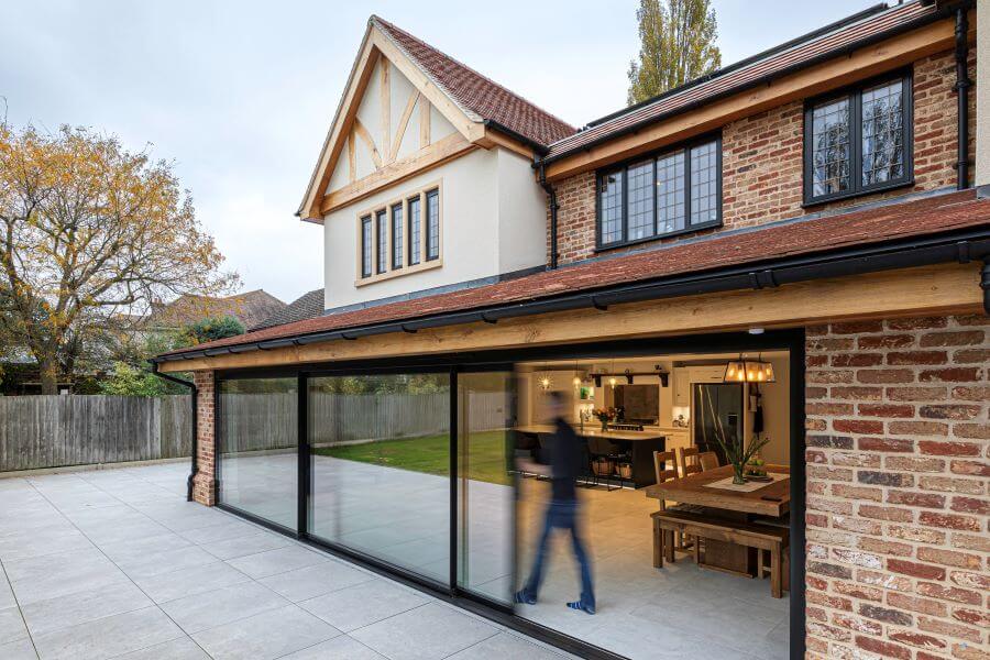 ARTISAN-GREY-LARGE-FORMAT-EXTERNAL-PORCELAIN-TILE. Image shows grey tiles on a patio next to a house with large sliding doors