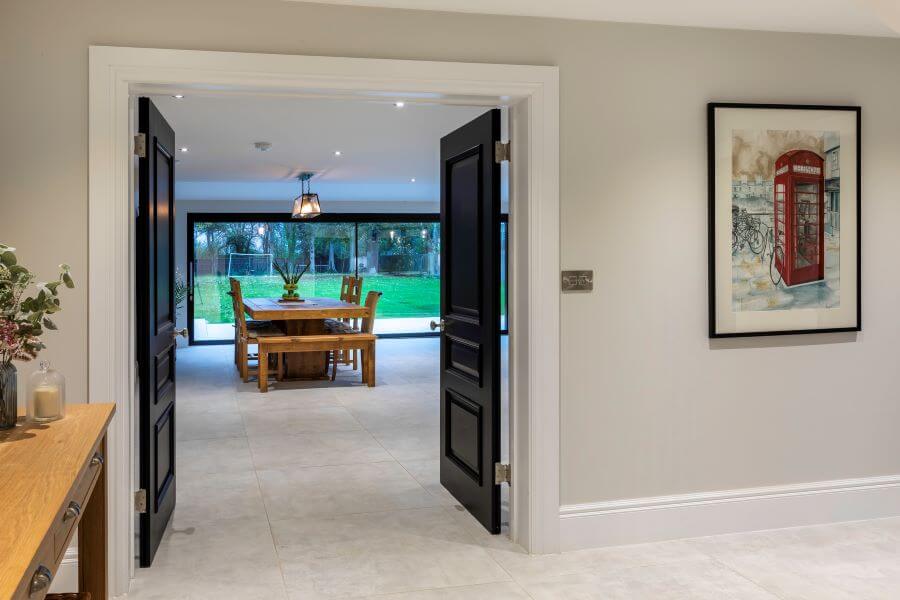 BEAT-WHITE-LARGE-FORMAT-CONCRETE-EFFECT-TILE. Image shows white large format tiles in a hallway leading into a dining room