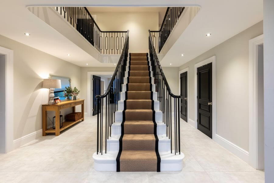 BEAT-WHITE-LARGE-FORMAT-CONCRETE-EFFECT-TILE. Image shows white large format tiles in a hallway with stairs