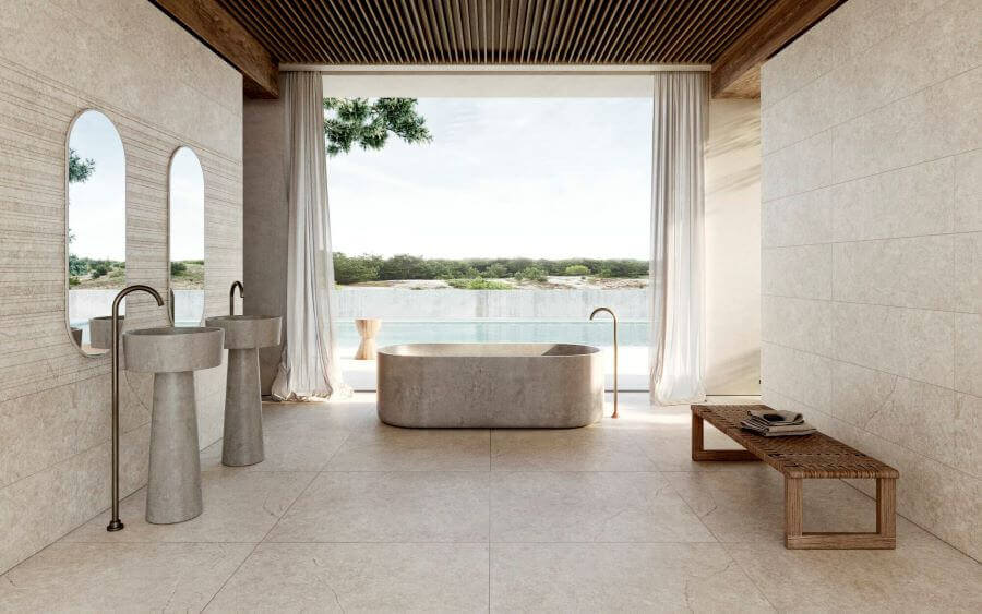 GRACE-SAHARA-STONE-LOOK-TILES-BATHROOM. Image shows sand stone look tiles in a bathroom with a designer bath and sinks