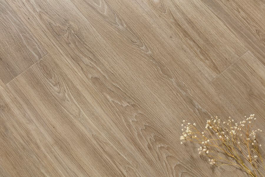 SERENITY-TAUPE-WOOD-PLANK-PORCELAIN-TILE. Image shows taupe wood plank porcelain tile on floor with flowers